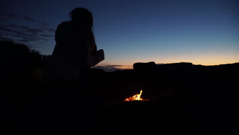Young-girl-alone-in-dark-woods-alone-by-campfire