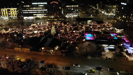 Drone-shot-of-Christmas-Market-in-Zürich,-Switzerland-flying-backwards-and-revealing-the-market-at-night