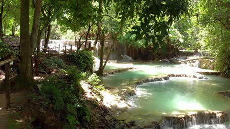 4k-pan-of-the-beautiful-turquoise-cascade-pools-at-the-famous-Kuang-Si-waterfalls-in-Laos,-Southeast-Asia