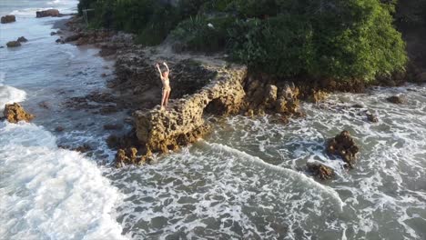 Mädchen,-Das-Während-Des-Sonnenuntergangs-Auf-Einem-Felsen-Am-Rande-Des-Brasilianischen-Ozeans-Steht