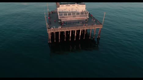 Newport-Beach-California-aerial-footage-featuring-the-pier,-beach,-water,-surfing,-swimming,-and-beach-goers