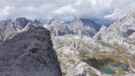 Aerial-view-of-Cross-on-summit-of-Monte-Paterno-Mountain-and-sea-in-valley-during-sunny-day---Three-Merlons,-Dolomites