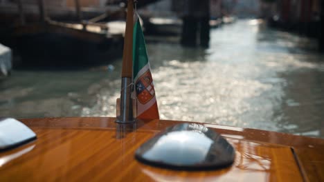 Classic-Boat-With-An-Italian-Flag-On-The-Canal-Of-Venice,-Italy