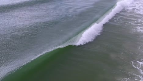 Slow-motion-drone-footage-of-an-ocean-wave-breaking-offshore