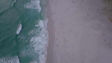 Aerial-footage-of-beach-and-waves-and-mountains-in-South-Africa,-Cape-Town,-Noordhoek