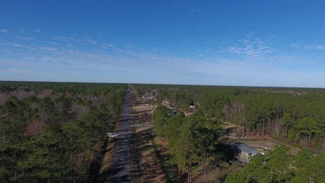 Drone-shot-rising-above-a-back-road-in-North-Carolina-towards-a-beautiful-blue-sky