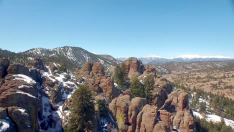 Drone-view-orbiting-around-spire-rocks-in-Colorado-mountains