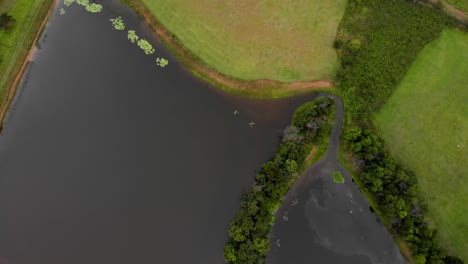 Aerial-panning-shot-of-a-lake-and-farmland