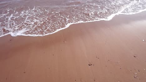 Roter-Sandstrand-Mit-Plätschernden-Wellen