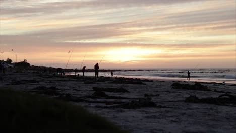 Fischer-Angeln-An-Einem-Strand-An-Der-Westküste-Südafrikas,-Kurz-Bevor-Die-Sonne-Untergeht