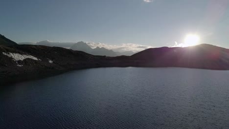 Drone-Dolly-shot-Sobre-El-Lago-Mountian-En-Los-Alpes-Suizos-Al-Atardecer-4k