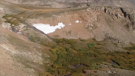 Aerial-views-of-Mosquito-Pass-in-Colorado-showing-fall-colors-on-large-meadows-with-touches-of-water-and-snow