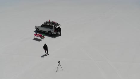 Drohnenaufnahmen-Aus-Der-Luft-Beim-Zubereiten-Des-Mittagessens-Und-Fotografieren-Im-Salar-De-Uyuni,-Boliviens-Größtem-Naturspiegel-Der-Welt