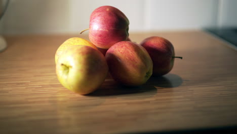 Manzanas-Rojas-En-El-Movimiento-De-La-Encimera-De-La-Cocina-De-Madera-De-Derecha-A-Izquierda