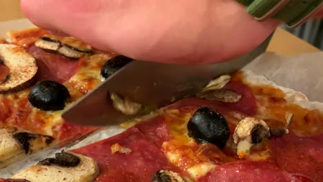 Hausgemachte-Pizza,-Die-Von-Einem-Studenten-Zu-Hause-Mit-Einem-Messer-Geschnitten-Wird