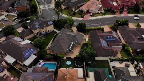Aerial-tilt-up-shot-of-a-suburban-area,-revealing-a-lake