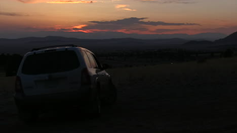 Ein-Einfacher-Clip-Eines-Losfahrenden-Geländewagens-Mit-Sonnenuntergang-Im-Hintergrund