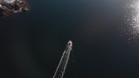 Drone-shot-chasing-a-boat-in-the-Lofoten-Islands,-Norway
