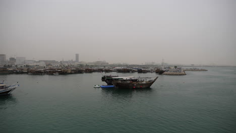 Skyline-of-beautiful-Doha---traditional-Dhow-boat-mooring-in-foreground---Doha,-Qatar
