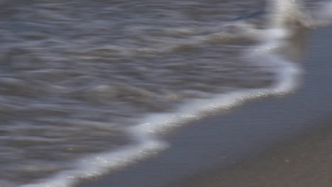 Weibchen,-Die-Auf-Strandspuren-Gehen,-Die-Von-Wasser-Bedeckt-Sind