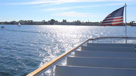 Old-Glory-Bewegt-Sich-Im-Wind-Auf-Der-Vorderseite-Eines-Bootes,-Das-Durch-Die-Gewässer-Der-Bucht-Von-San-Diego-Navigiert