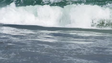 Small-wave-breaks-into-foam-swash,-tumbles-to-shore