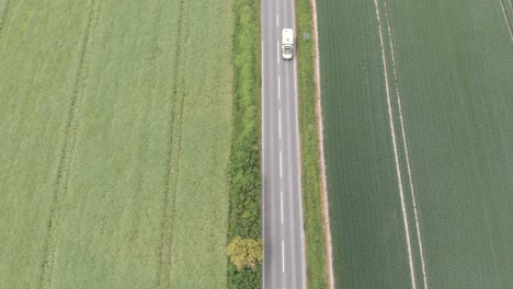 An-aerial-view-of-a-country-road-in-Wiltshire,-England-following-an-ambulance