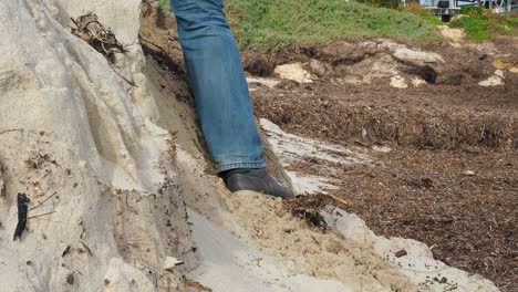 Eroded-beach-sand-bank-collapses-as-man-in-jeans-steps-down