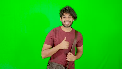 indian-tourist-standing-and-looking-on-camera-with-green-background---green-screen
