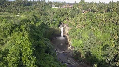 DRONE-PEDESTAL-DOWN-ON-FOREST-WITH-WATERFALL,-Tegenungan,-beautiful-cascade-in-Bali,-Indonesian