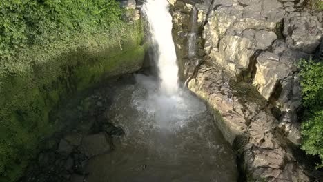 AERIAL-SHOT-OVER-WATERFALL,-Tegenungan,-strong-cascade-in-Bali,-Indonesia