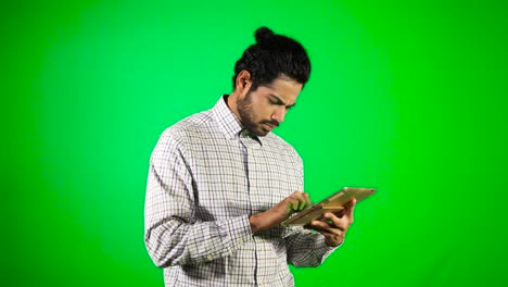 guy-using-mobile---tablet-with-green-screen-and-green-background-indian-guy-with-green-screen
