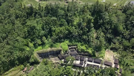 AERIAL-BACKWARD-TILT-SHOT-Above-Ancient-Temple-Gunung-Kawi,-in-Ubud,-Bali-in-Indonesia