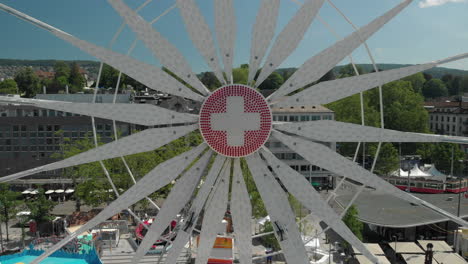 Schöner-Luftdrohnenkranschuss,-Der-Während-Des-Zürichfestes-Rückwärts-Vom-Riesenrad-Des-Vergnügungsparks-Und-Vom-Freifallturm-Mit-Der-Stadt-Und-Dem-Zürichsee,-Schweiz-Im-Hintergrund-Fliegt