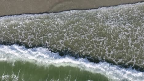 Aerial-view-of-waves-straight-down-on-sea-shore