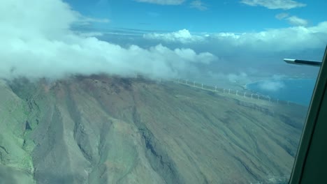 Looking-back-out-the-tail-of-a-Cessna-back-towards-wind-mills-on-Maui,-Hawaii