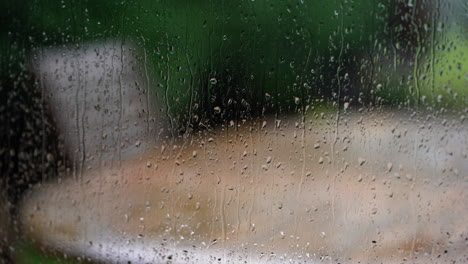 Rain-drops-running-down-window-looking-out-to-garden