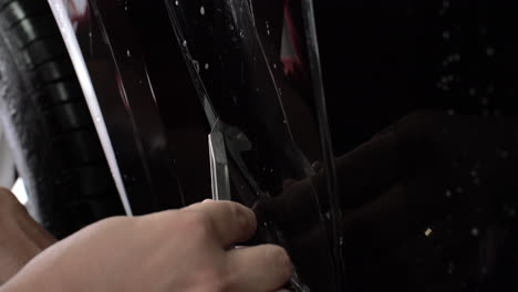 Close-up-of-precisely-cutting-paint-protection-film-on-a-car-to-make-a-perfect-fit-during-application