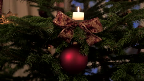 Un-árbol-De-Navidad,-Una-Chuchería,-Una-Cinta-Y-Una-Vela,-Fhd-Apple-Prores