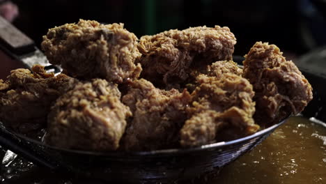 Close-up-of-straining-fried-chicken-after-deep-frying-in-a-wok
