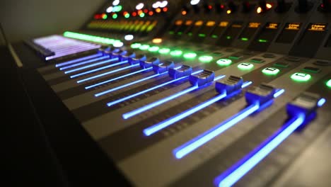 Close-up-of-mixer-with-blue-buttons-moving-up-and-down-on-a-TV-studio-live-broadcasting