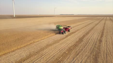 A-Midwest-farmer-harvesting-a-soybean-field-with-a-combine,-tractor,-and-auger-wagon