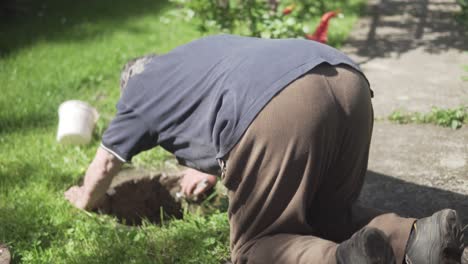 Old-man-lies-on-the-ground-and-inspects-the-sewage-hole
