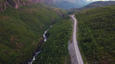 Viajando-Solo-Por-Un-Largo-Camino-Paralelo-Al-Río-En-Un-Valle-Verde-Y-Profundo,-En-El-Norte-De-Noruega