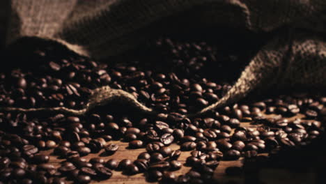 Close-shot---camera-moving-away-from-a-bag-of-freshly-roasted-coffee-beans-on-a-wooden-table