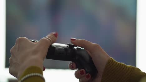 Female-gamer-hands-game-controller-television-in-background