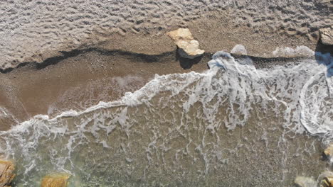 Drone-shot-of-sand-an-waves,-Mourtitza-beach,-Greece