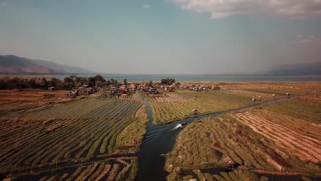 Rural-Myanmar,-Aerial-View-of-Boat-in-Canal-Between-Floating-Island-Gardens,-Agricultural-Fiends-in-Inle-Lake