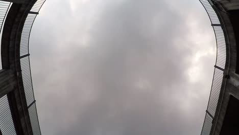 Timelapse-of-clouds-slowly-covering-the-sky-from-the-bottom-of-a-circular-parking-lot
