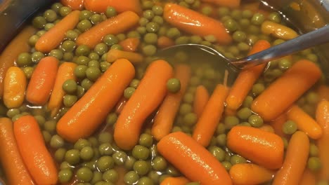 Canned-peas-and-carrots-are-heated-in-a-saucepan